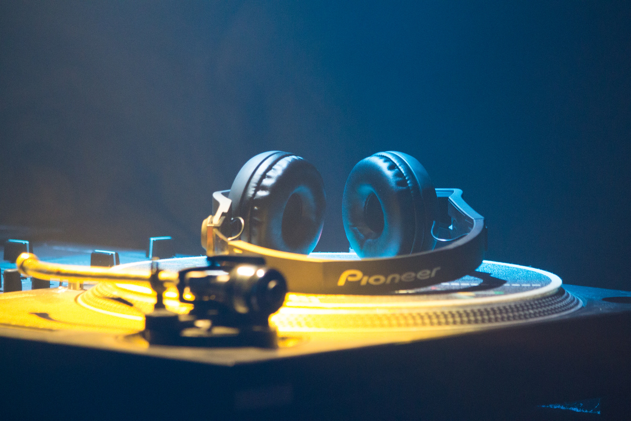 Modern headphones on disc of DJ console in nightclub